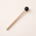 A mallet with a light handle and a round black head.