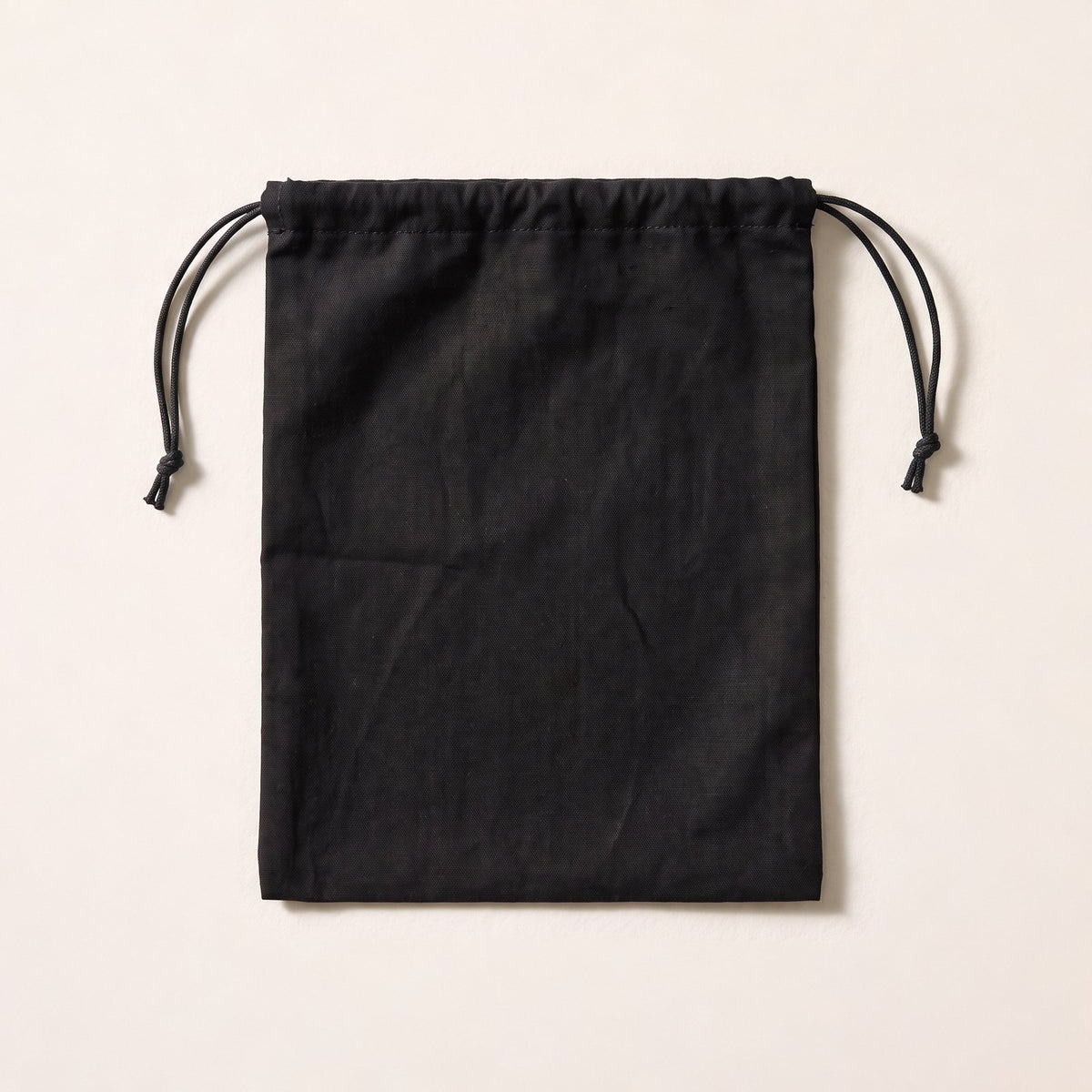 A plain black cloth drawstring bag with a black cord.