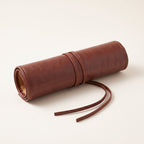 The brown roll-up case rolled up and tied with its thin cord.