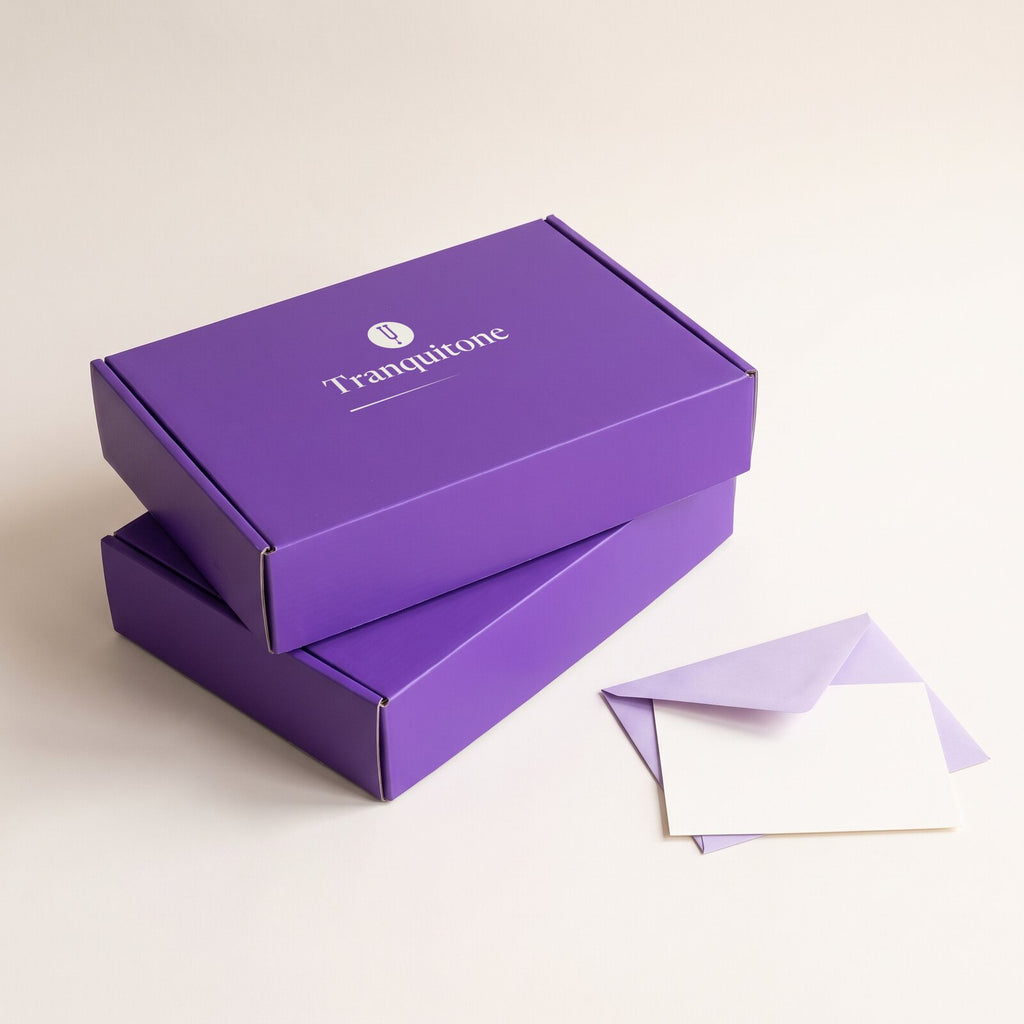 Two Tranquitone gift boxes stacked, with two envelopes and blank note cards beside them.