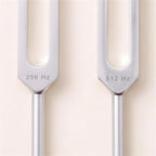 Close-up of The Three's 256 Hz and 512 Hz forks below the prongs, engraved 256 Hz and 512 Hz.