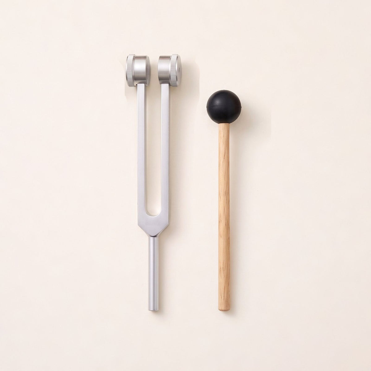 The 136.1 Hz tuning fork, close to C sharp, with a weight on each prong, beside its wooden mallet.
