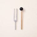 The 512 Hz tuning fork, a C, without weights, beside its wooden mallet.